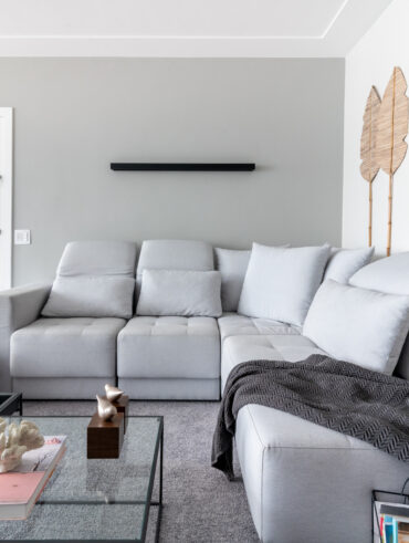 Sala de estar com sofá, mesa de centro, mantas decoração de palha na parede