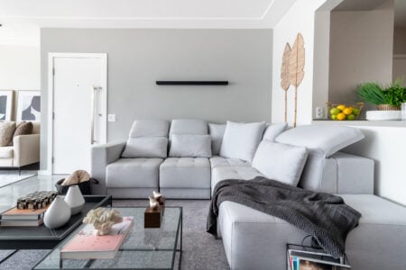 Sala de estar com sofá, mesa de centro, mantas decoração de palha na parede