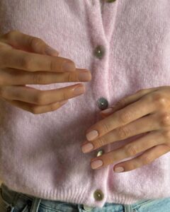 Mãos de pele clara, com unha curtinha no estilo soap nails