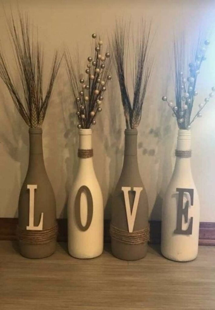 Quatro garrafas pintadas decoradas com a palavra love