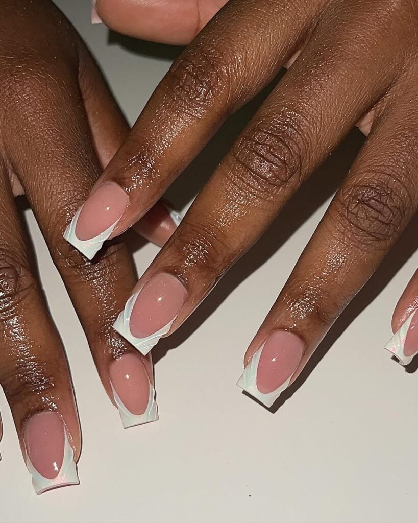 Mão de pele negra, com unha longa e quadrada e esmalte branco com nail art francesinha e gel em 3D
