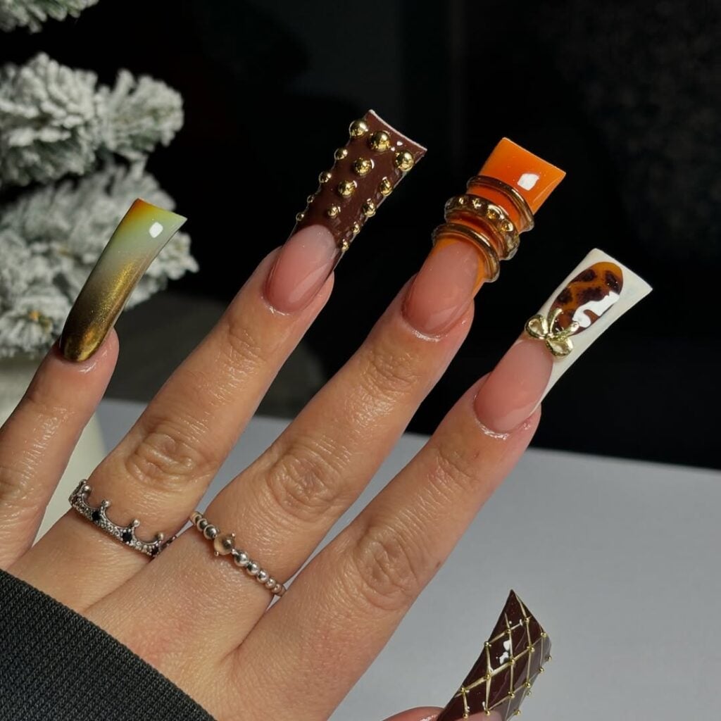 Mão de pele clara, com anéis em prata e duck nail com francesinha colorida e charms