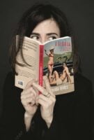 Mulher escondendo-se atrás de um livro
