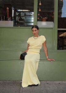 Mulher de pele clara, com saia longa amarelo-manteiga e blusa da mesma cor