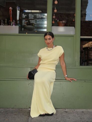 Mulher de pele clara, com saia longa amarelo-manteiga e blusa da mesma cor