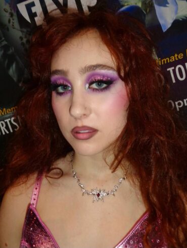 Chappell Roan, com body de alcinha rosa, cabelo ruivo e maquiagem new wave com sombra colorida
