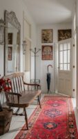 Corredor com tapete passadeira vermelho, banco em madeira e espelho com moldura ornamentada