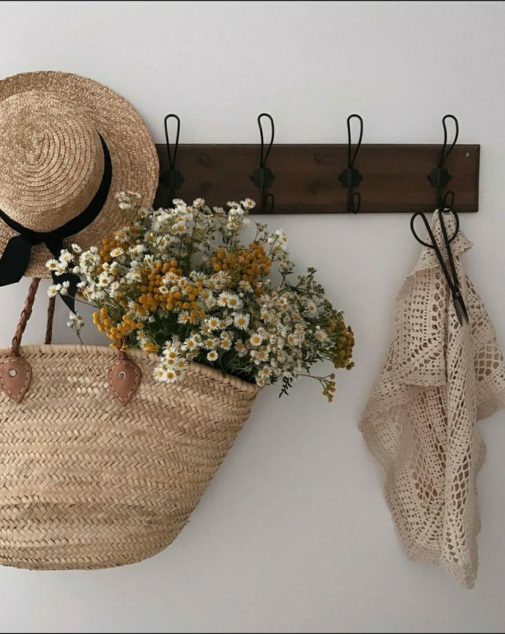 Cabideiro com bolsa e chapéu de palha e flores