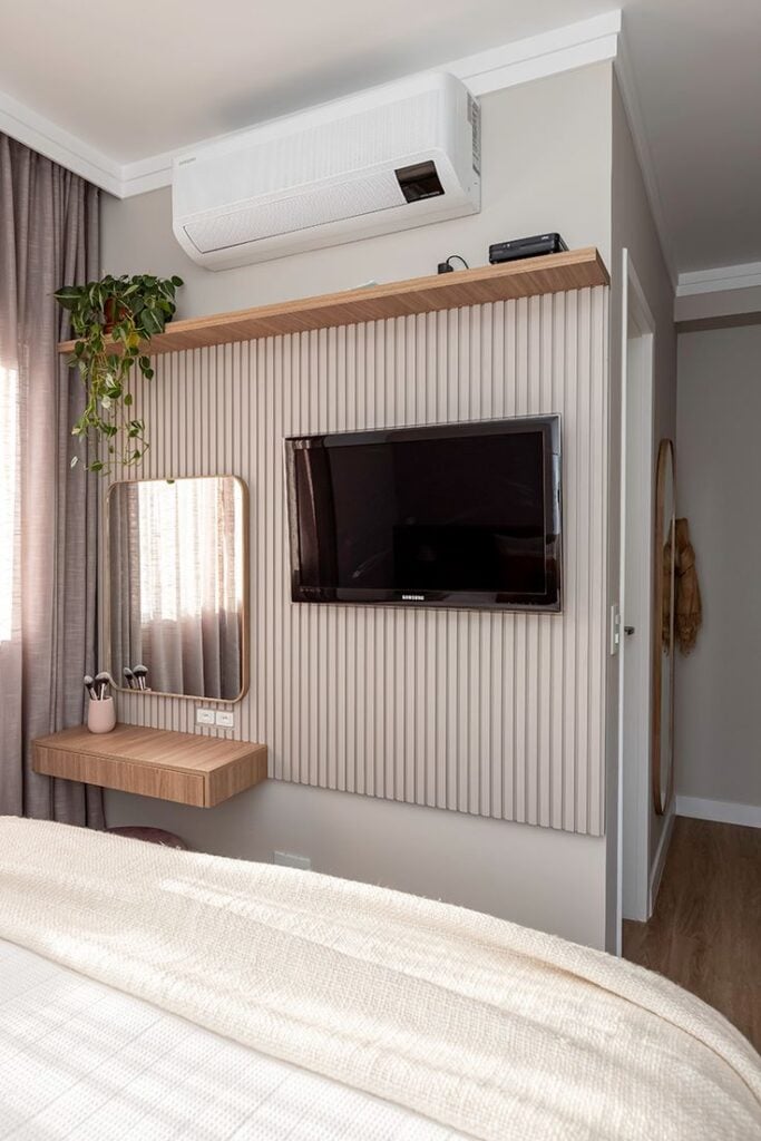 Quarto com painel de TV ripado em cinza-claro