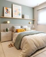 Quarto de casal em tons neutros, com cabeceira ripada e quadros na prateleira