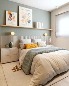 Quarto de casal em tons neutros, com cabeceira ripada e quadros na prateleira