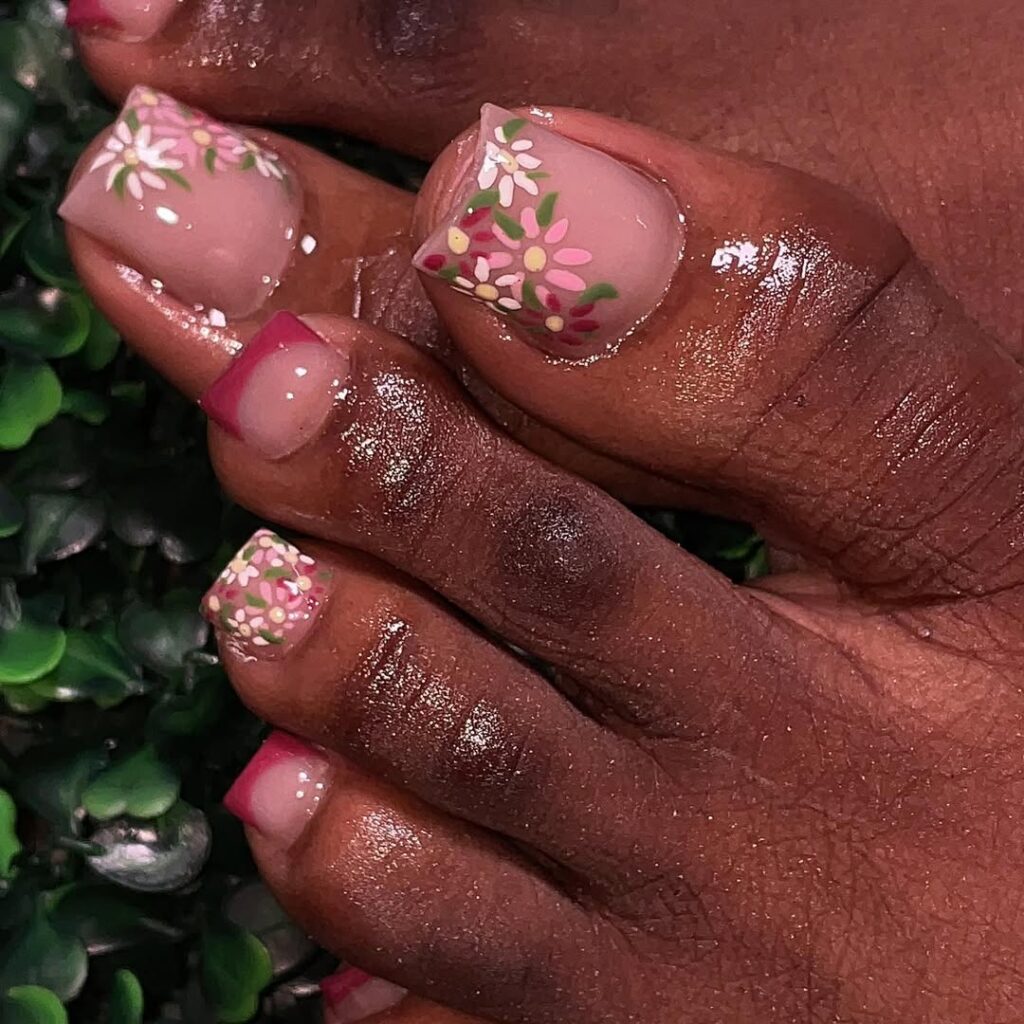 Pé de pele negra com nail art rosa de flor