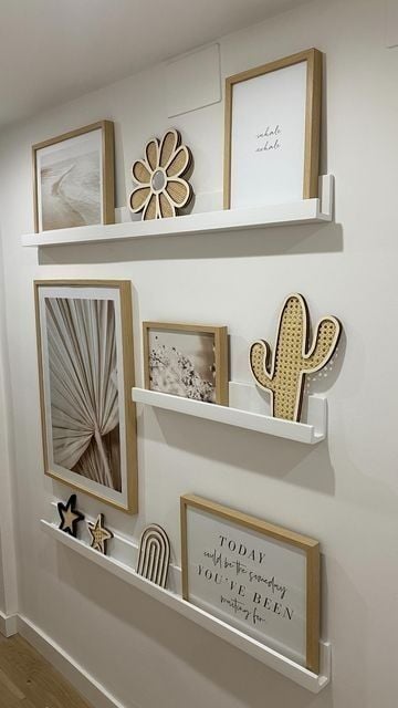 Corredor branco com pequenas prateleiras com quadros de molduras douradas