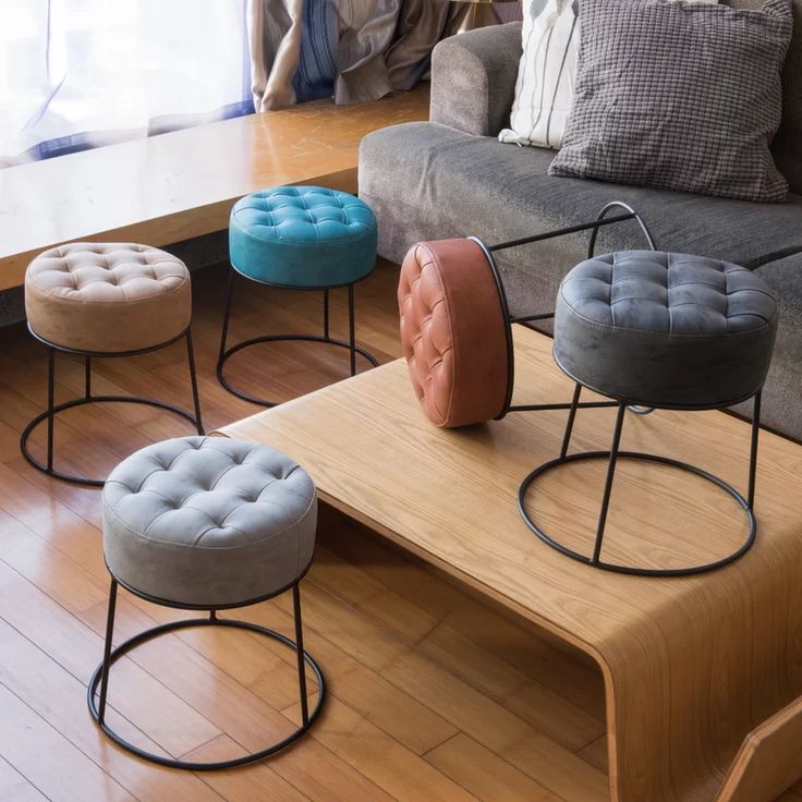 Puff com assento no estilo capitonê e base em metal preto