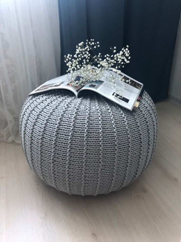 Puff cinza de crochê com revista em cima