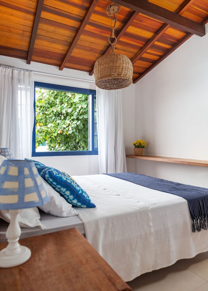 Quarto de casal azul e branco, com cama e prateleira