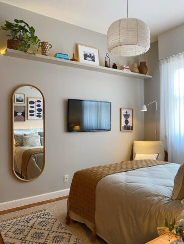 Quarto de casal com cama, tapete, passadeira, TV, espelho e prateleira