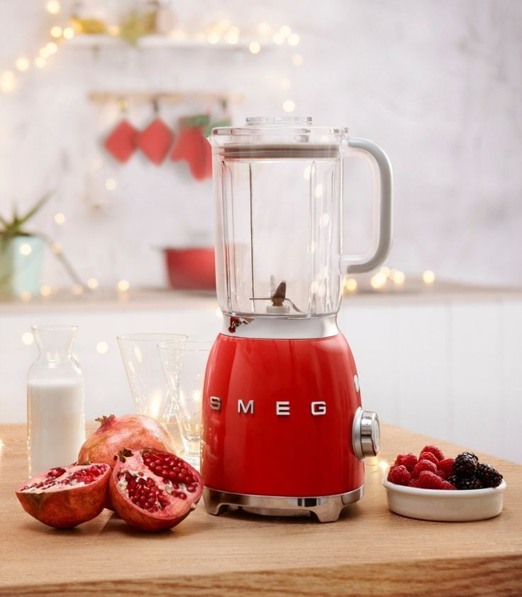 Liquidificador vermelho com frutas ao lado