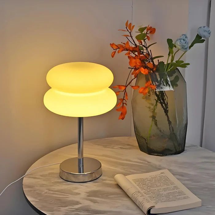 Mesa com luminária, livro e vaso de flores