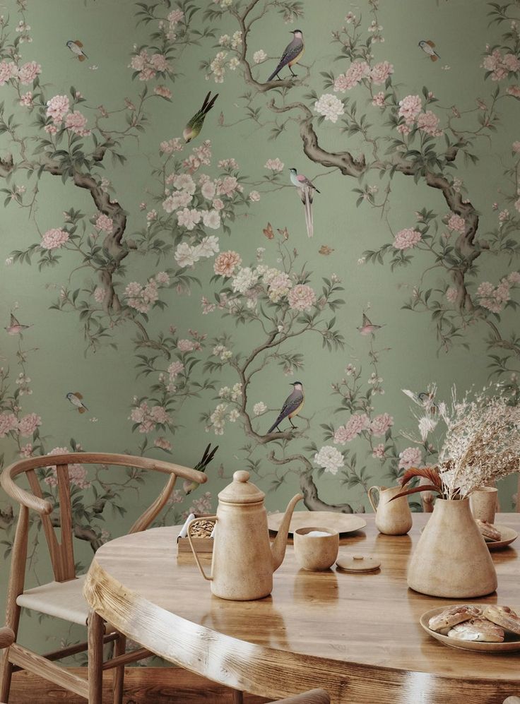 Mesa e cadeira com papel de parede ao fundo com flores e pássaros
