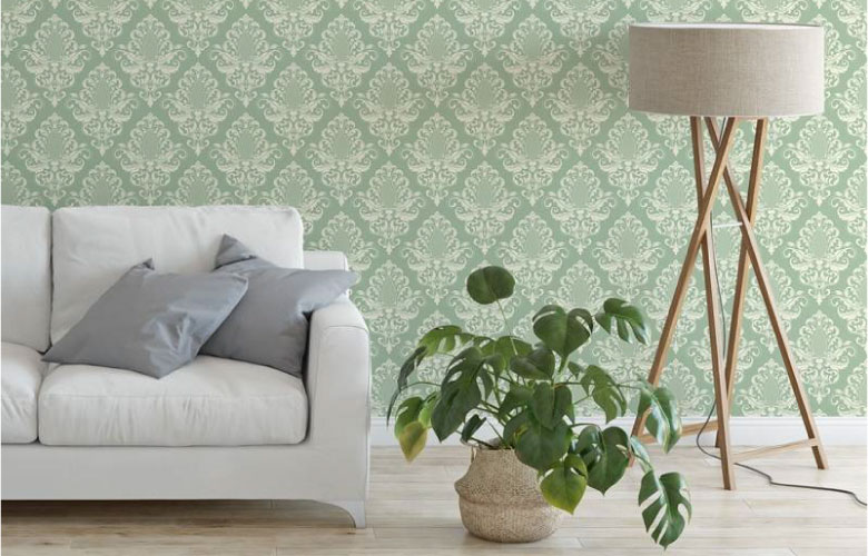 Sala com sofá claro, planta e papel de parede azul e branco