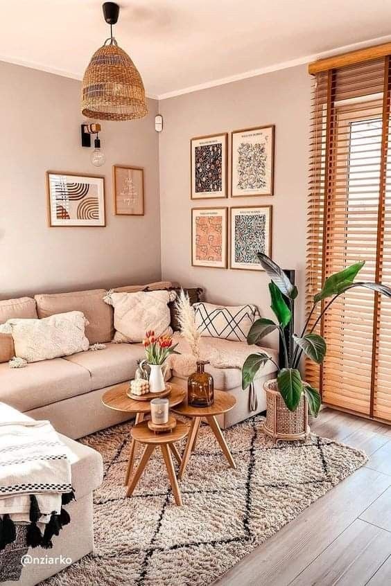Sala com sofá, mesinhas de centro, plantas e quadros