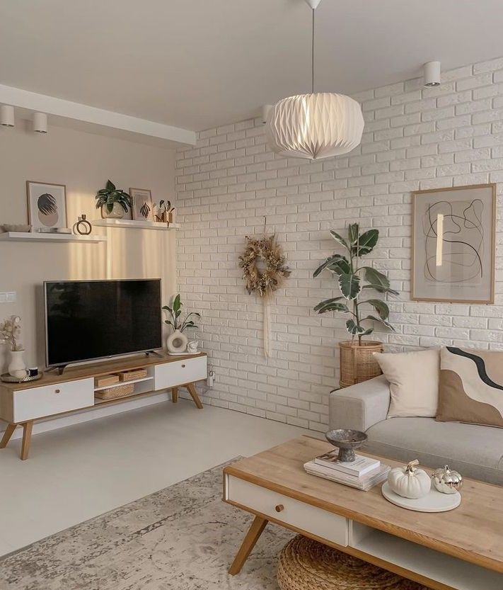 Sala branca de tijolinhos, móveis em madeira e cores claras