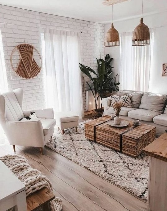 Sala com sofás em tons claros, pendentes de fibras naturais, mesa de centro de madeira