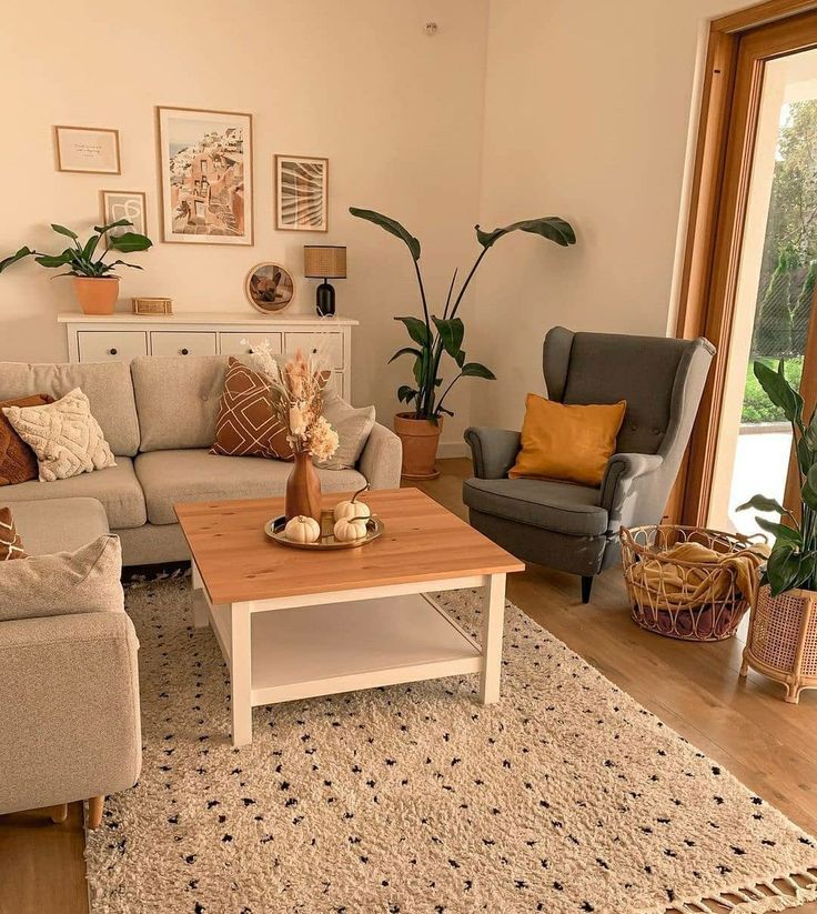Sala pequena com sofás e poltrona, tapete na cor neutra e mesa de centro