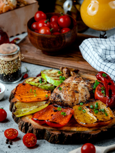 Frango e pimentões assados em cima de uma bandeja de madeira