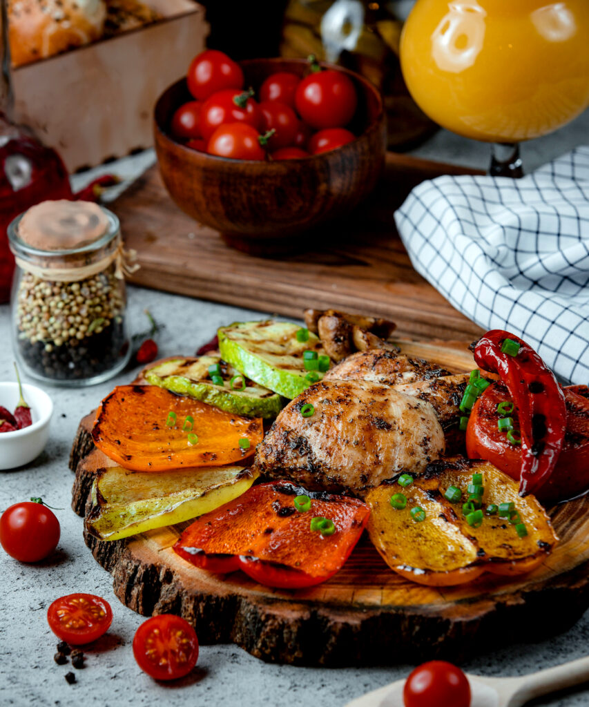 Frango e pimentões assados em cima de uma bandeja de madeira