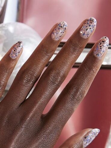 Mão de pele preta, com unha amendoada com glitter