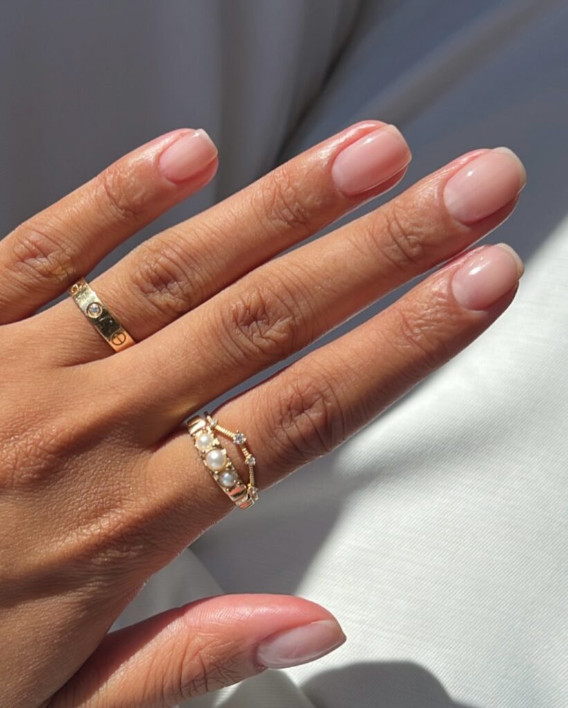 Mão de pele 'média', com anéis em dourado e unha curta e squoval natural