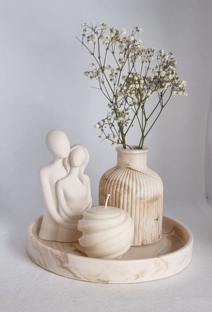 Bandeja com escultura de casal, vela e vaso com florzinhas