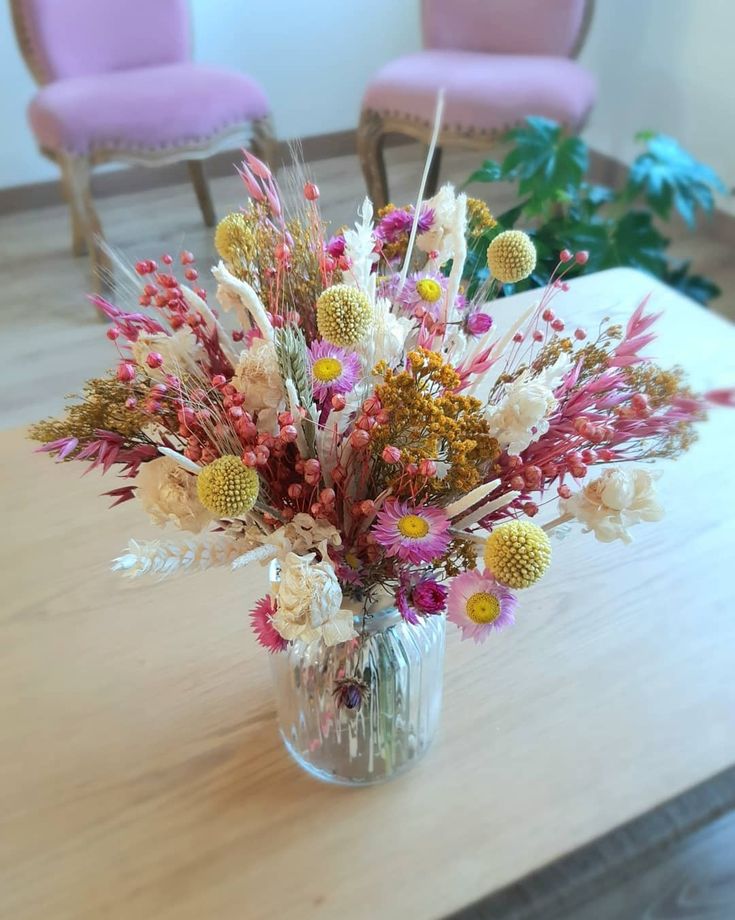 Vaso de vidro com flores secas rosas, brancas e amarelas