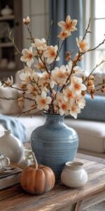 Mesa de centro de sala com vaso azul e flores claras