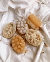 lençol claro com sabonetes e buchas vegetais