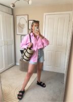 Mulher jovem com look de camisa rosa