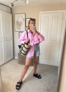 Mulher jovem com look de camisa rosa