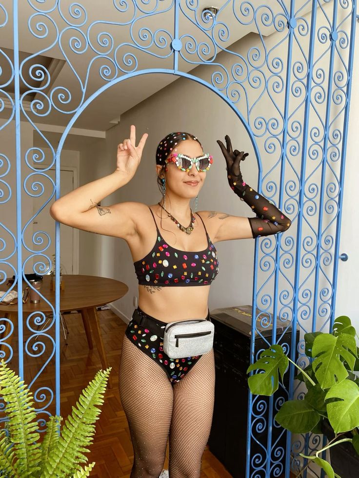 Mulher jovem e magra com fantasia de carnaval com top e hot pant preto.