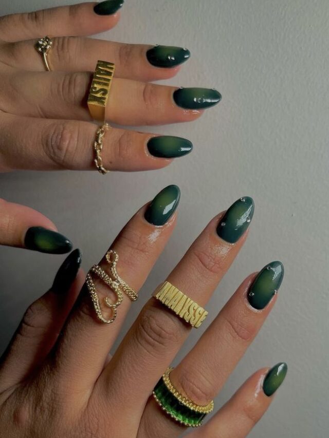 Mão de pele branca, com unha longa e esmalte verde, com nail art aura nails