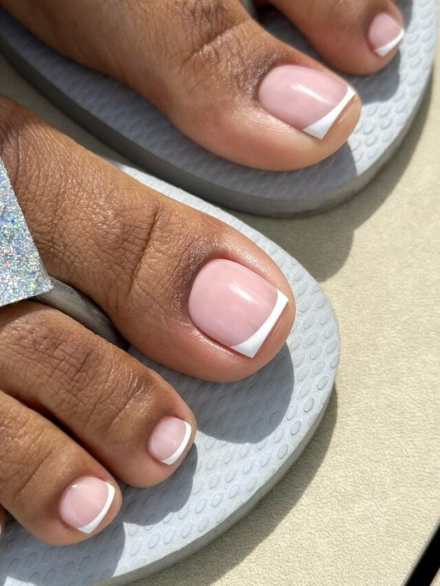 Pé de pele negra com esmalte rosa e branco e francesinha