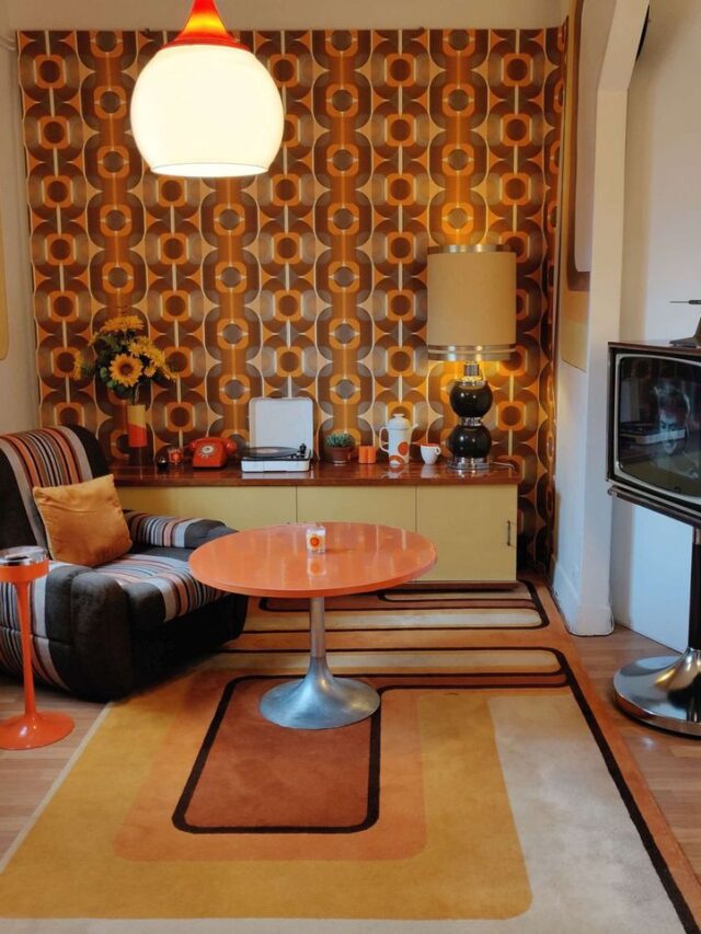 Sala com papel de parede geométrico em tons de laranja e marrom