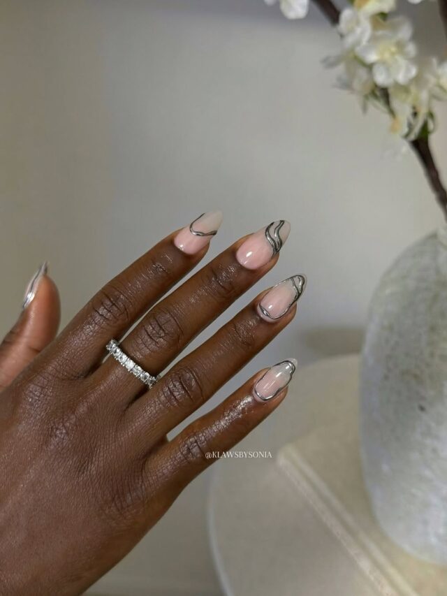 Mão de pele negra, com unha amendoada, com esmalte prata e técnica de nail art em 3D cromado