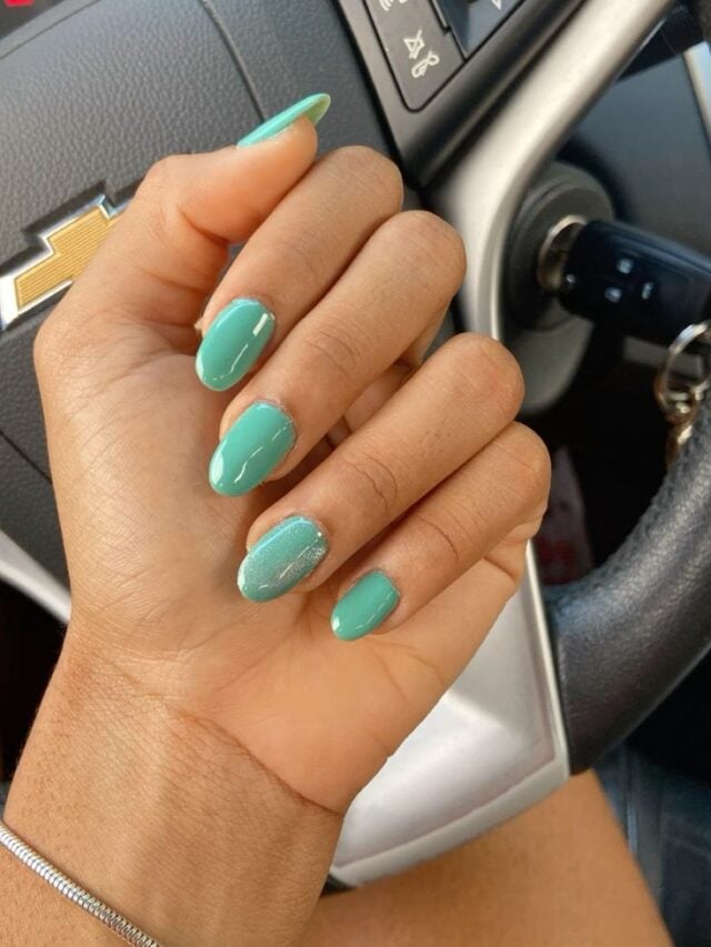 Mão de pele branca, com esmalte verde-água
