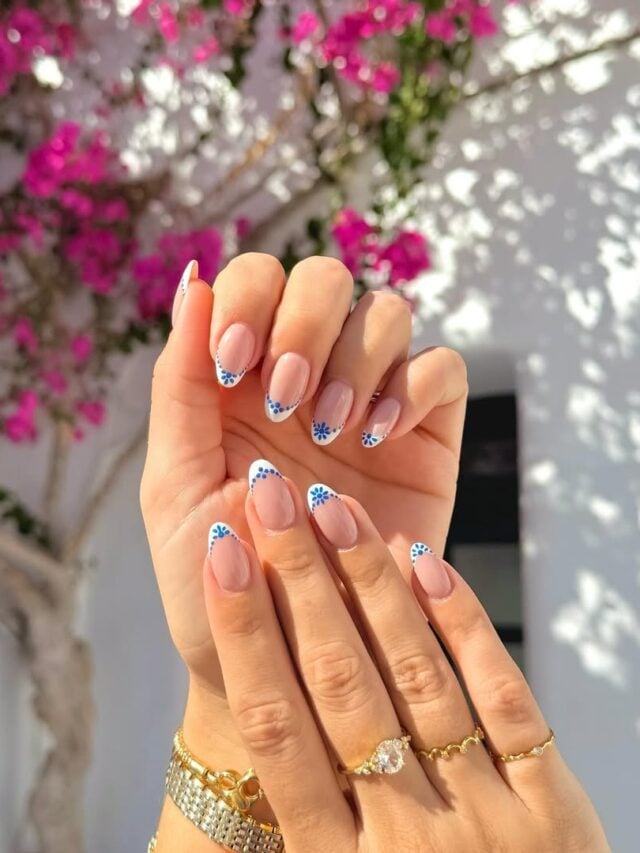 Mão de pele branca, com unha longa e amendoada, com esmalte azul e branco com nail art em técnica greece nails