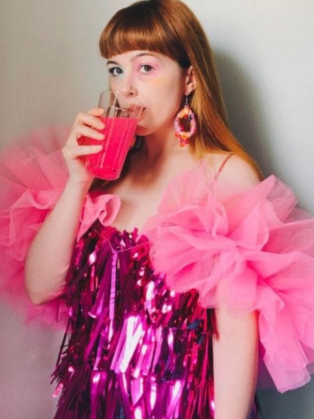 Mulher jovem e magra com vestido rosa de mangas bufantes