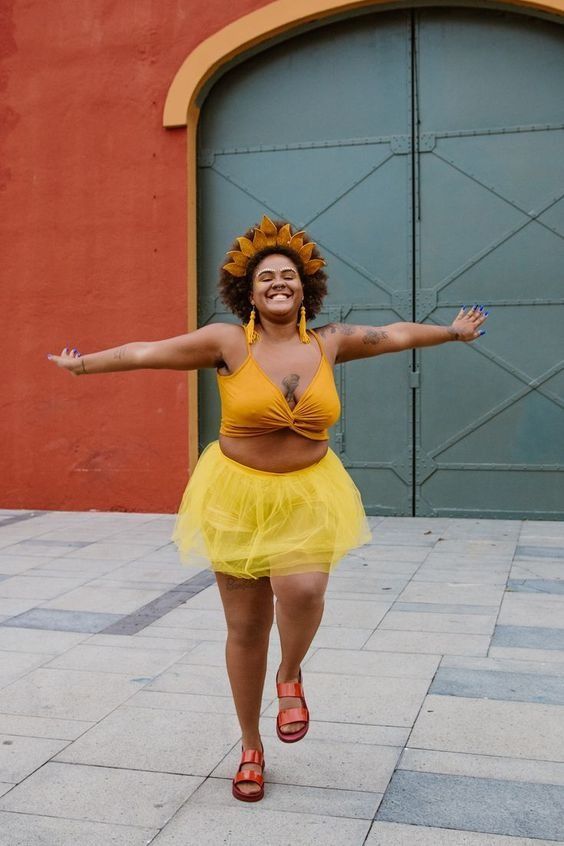 Mulher jovem de pele negra com fantasia de sol para o carnaval