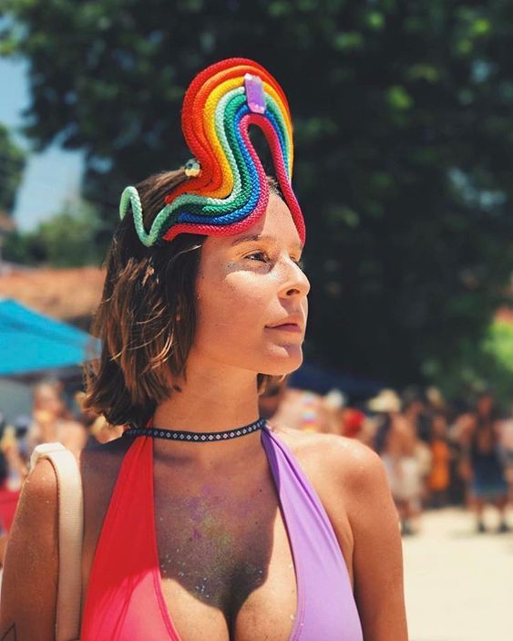 Mulher jovem com look de carnaval e tiara de arco-íris