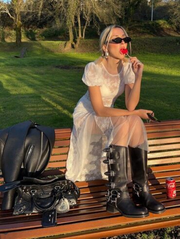 Mulher de pele clara, com vestido branco rendado e biker boots